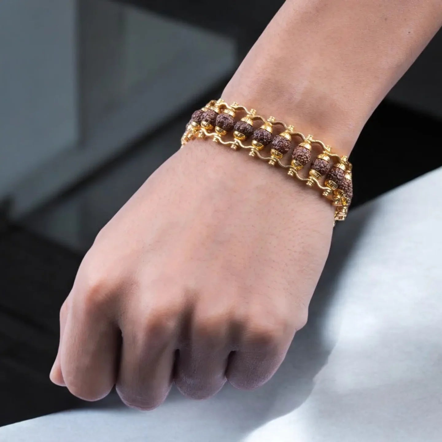 Gold bracelet on a wrist with a blurred background
