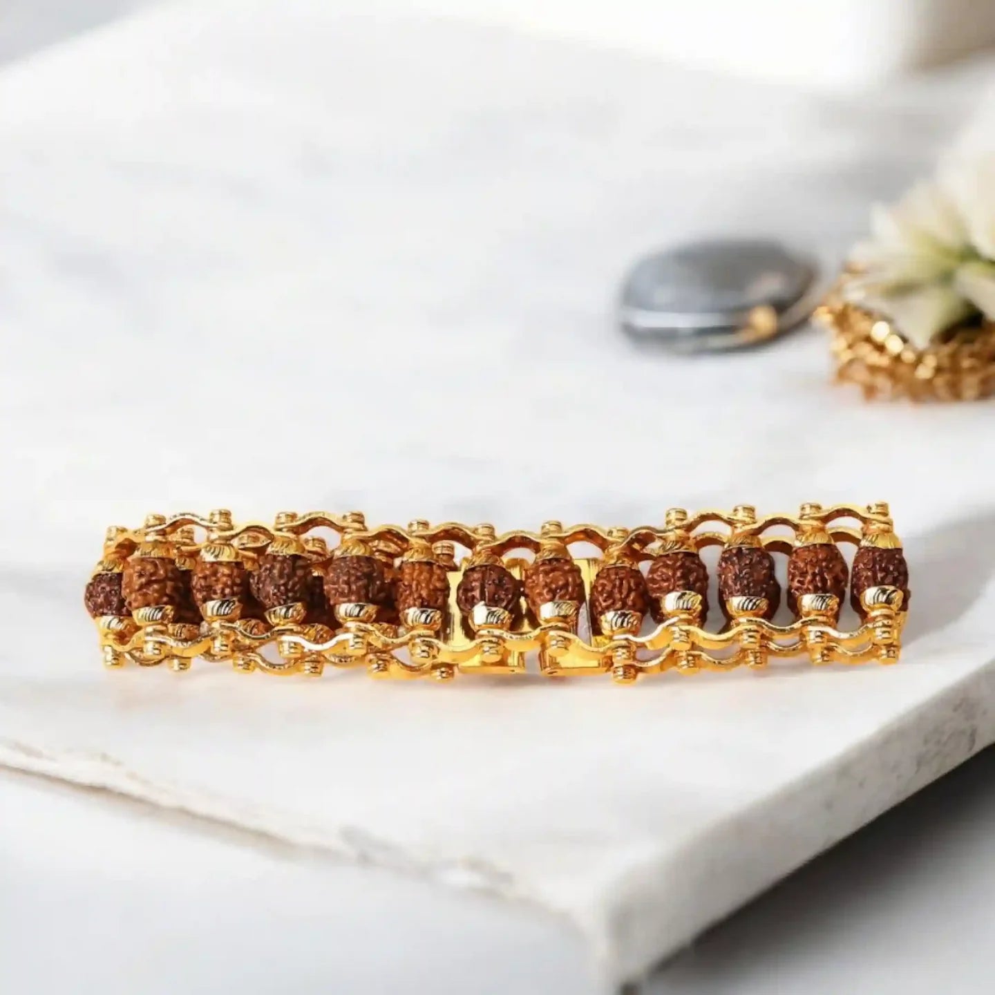 Gold bracelet with brown beads on a white surface