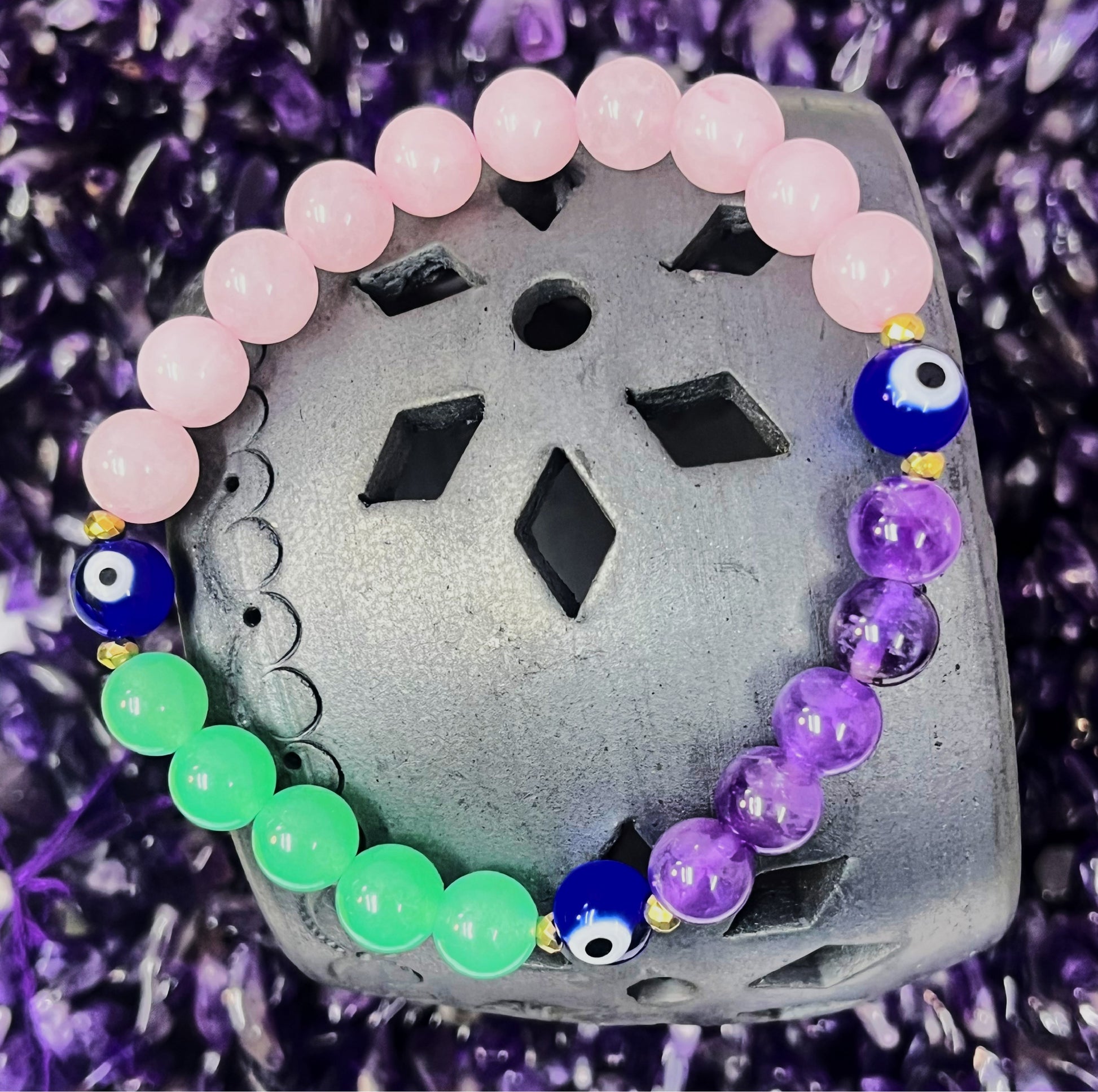 Multicolored beaded bracelet on a textured surface with a purple background