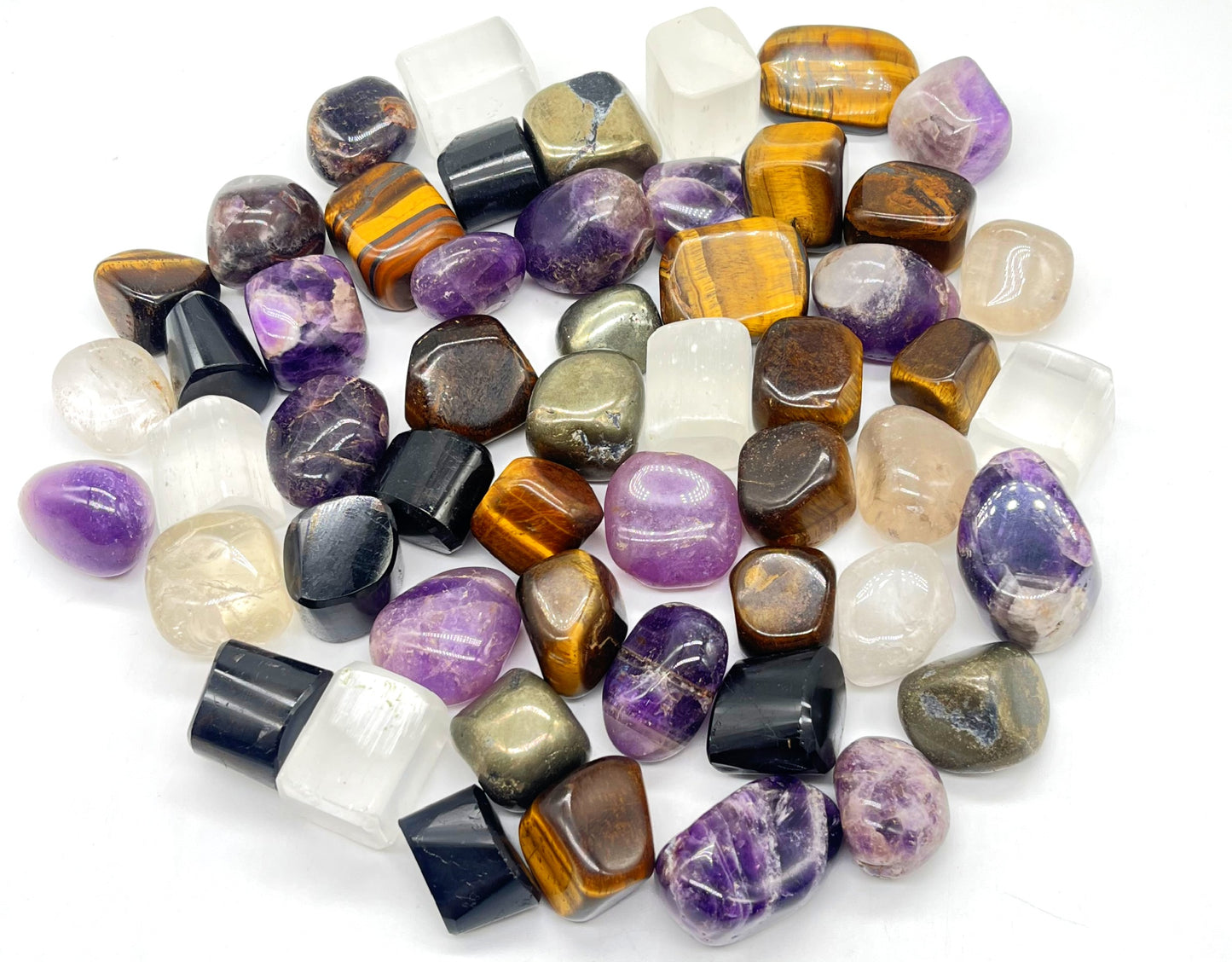 Assorted tumbled gemstones on a white background