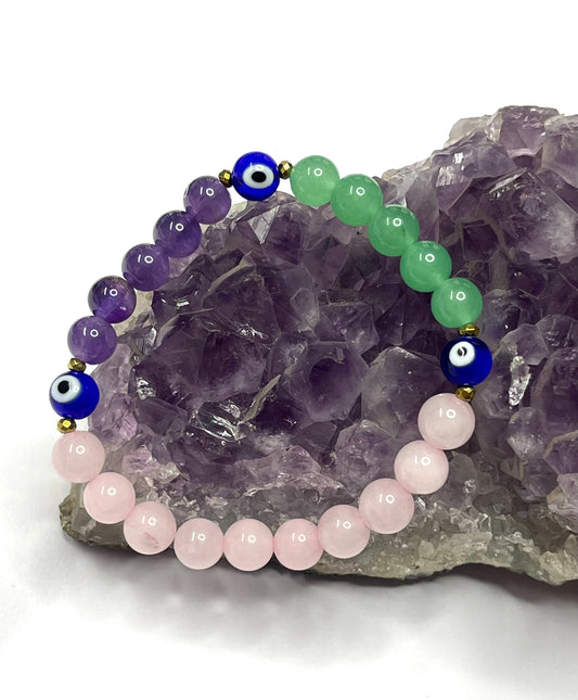 Close-up view of Divine Guardian bracelet showing natural crystal beads and evil eye charm detail