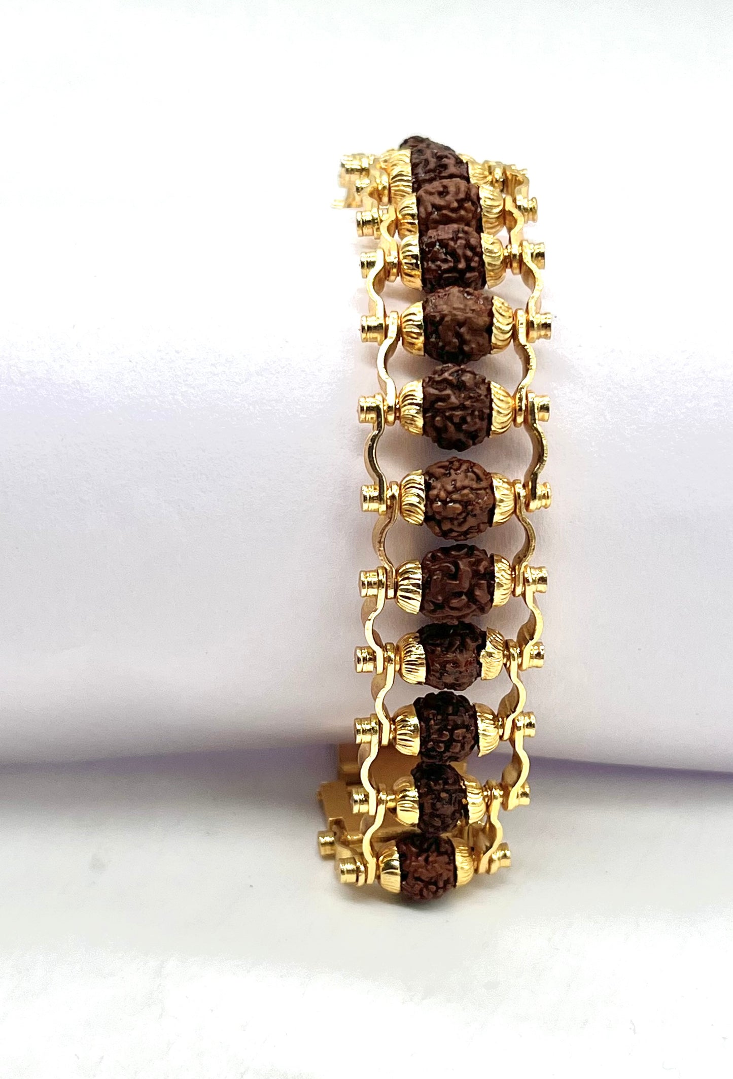 Gold bracelet with brown stones on a white background