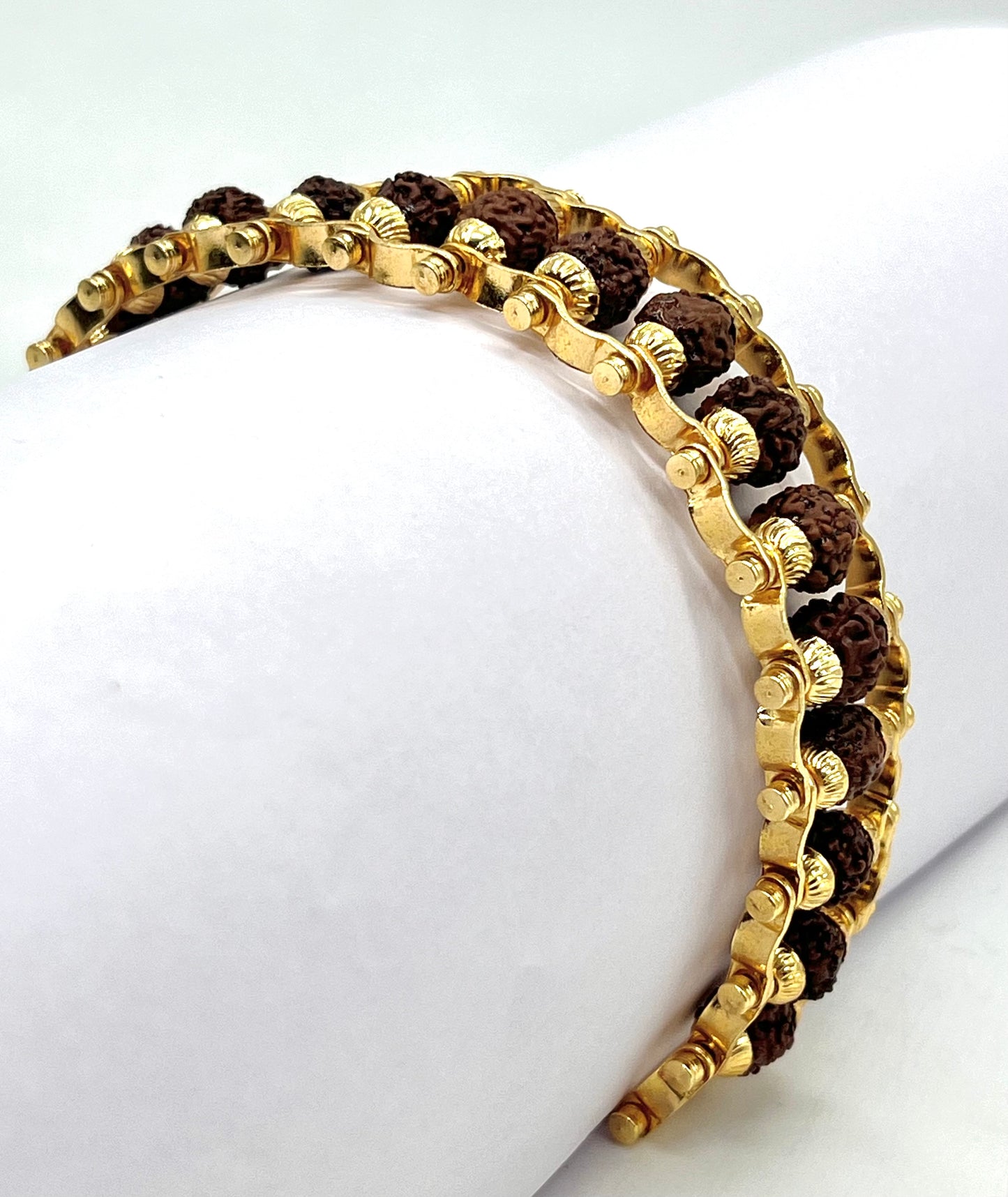 Gold and brown beaded bracelet on a white surface