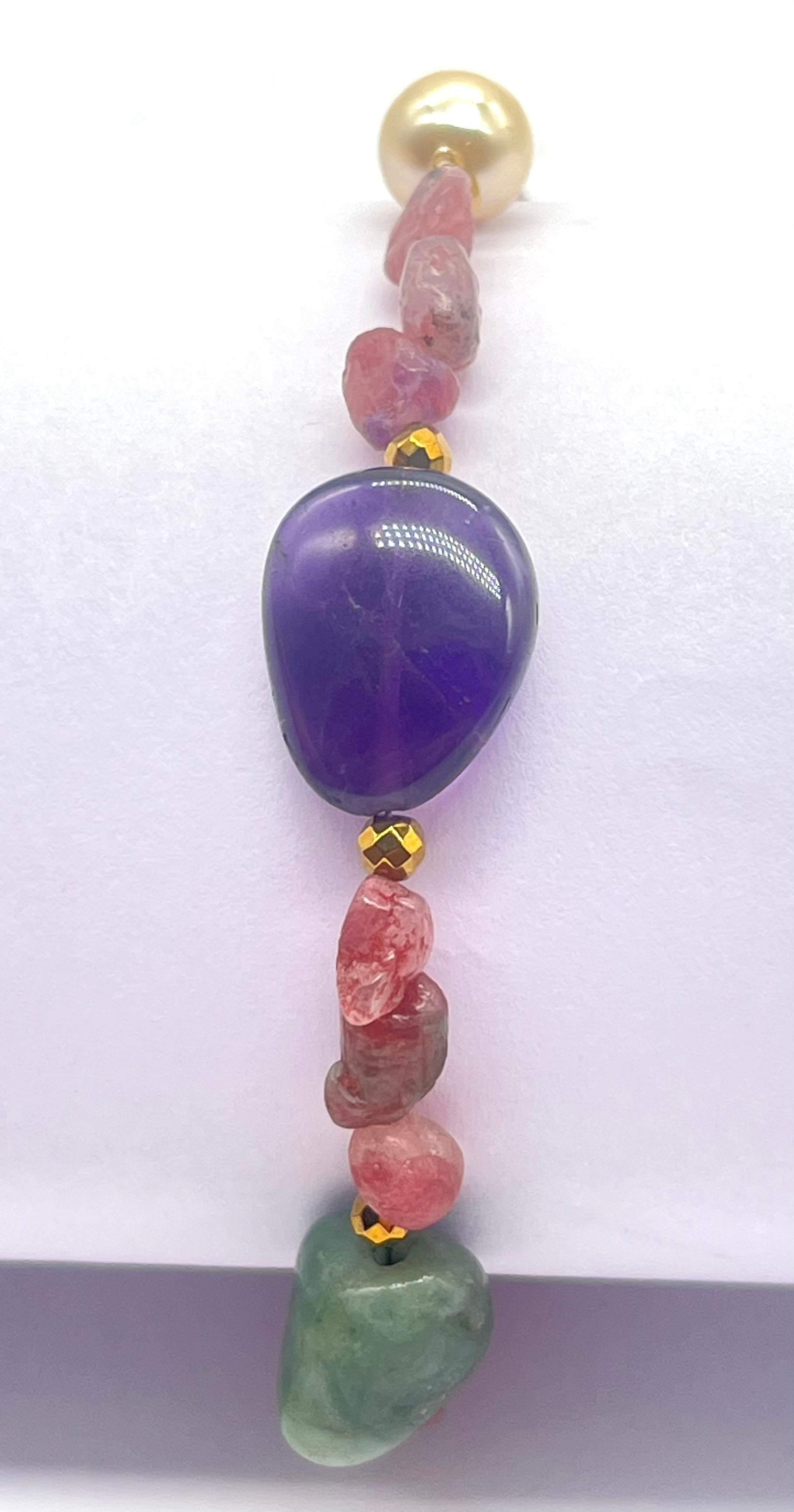Beaded necklace with purple, pink, and green beads on a white background